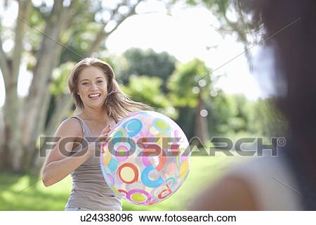 Two young females friends playing with a beach ball View Large Photo Image Stock Photograph - Two young females friends playing with a beach ball. Fotosearch