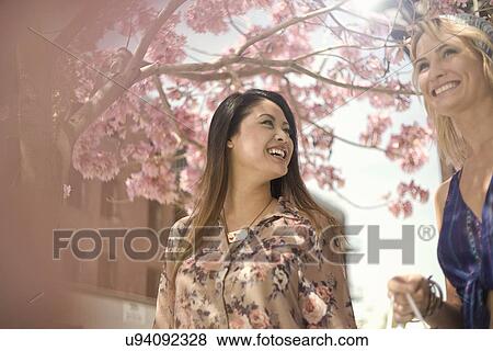 Stock Photo - Two young women chatting on city street. Fotosearch