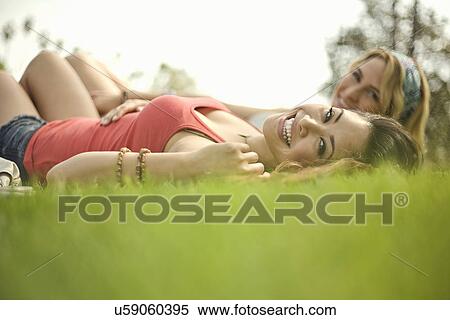 Stock Photography - Two young women lying down in park. Fotosearch