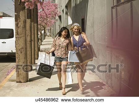 Stock Image - Two young women shopping in the city. Fotosearch