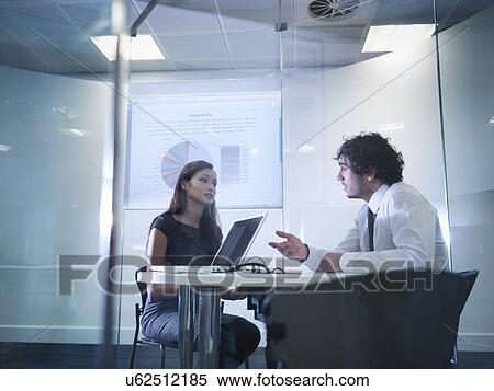 Stock Photography - View through glass windows of meeting room of business colleagues in discussion. Fotosearch
