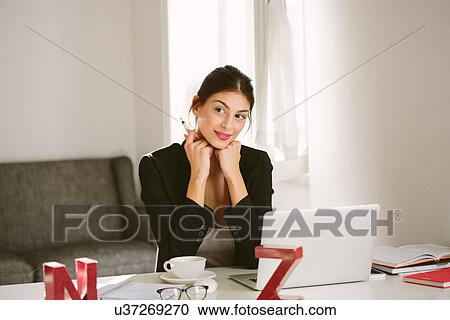 Woman at desk with laptop View Large Photo Image Stock Image - Woman at desk with laptop. Fotosearch