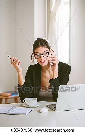 Woman at desk with laptop View Large Photo Image Stock Photograph - Woman at desk with laptop. Fotosearch