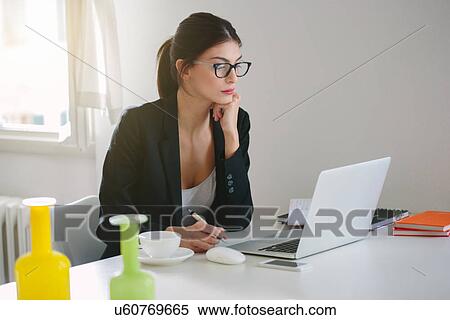 Woman at desk with laptop View Large Photo Image Stock Photography - Woman at desk with laptop. Fotosearch