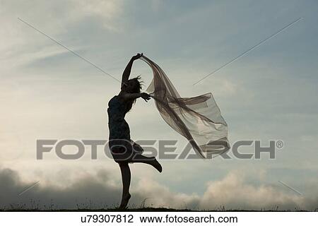 Woman dancing with sheer fabric over head View Large Photo Image Stock Image - Woman dancing with sheer fabric over head. Fotosearch