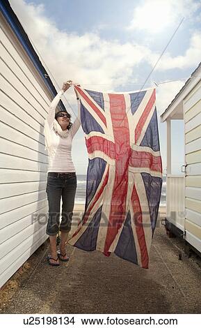 Woman hanging union jack on washing line, Southwold, Suffolk, UK View Large Photo Image Picture - Woman hanging union jack on washing line, Southwold, Suffolk, UK. Fotosearch