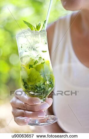 Stock Photo - Woman holding glass of mojito. Fotosearch