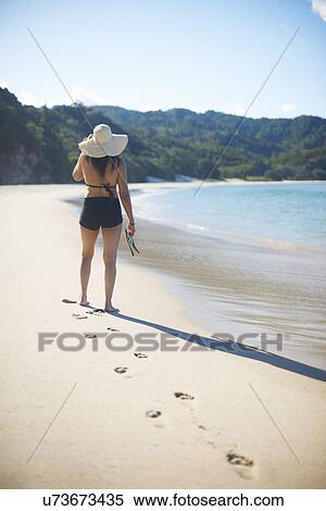 Stock Photography - Woman on New Chums beach, Coromandel Peninsula, New Zealand. Fotosearch