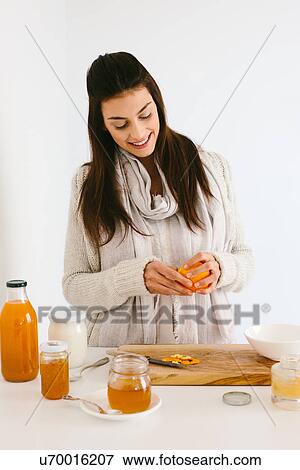 Stock Photo - Woman peeling orange. Fotosearch