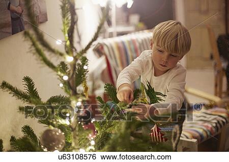 Young boy decorating tree at christmas View Large Photo Image Stock Photograph - Young boy decorating tree at christmas. Fotosearch
