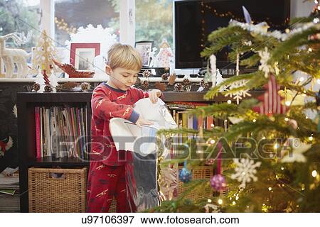 Young boy unwrapping gift at christmas View Large Photo Image Stock Photo - Young boy unwrapping gift at christmas. Fotosearch