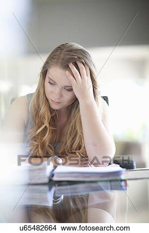Young businesswoman busy checking through file View Large Photo Image Picture - Young businesswoman busy checking through file. Fotosearch