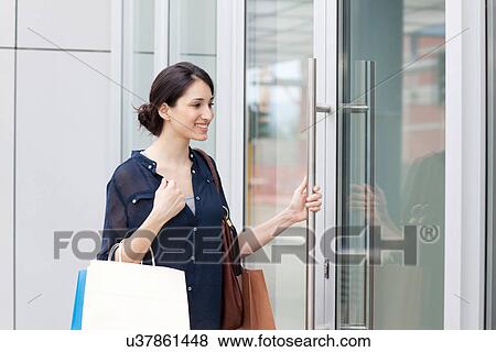 Stock Photo - Young businesswoman carrying shopping bags. Fotosearch