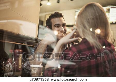 Stock Photo - Young couple chatting in cafe. Fotosearch