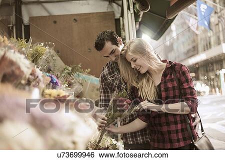 Young couple choosing flowers at flower stall View Large Photo Image Stock Photograph - Young couple choosing flowers at flower stall. Fotosearch