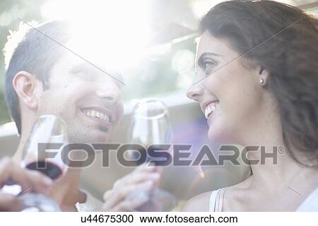 Stock Image - Young couple enjoying wine tasting at vineyard. Fotosearch