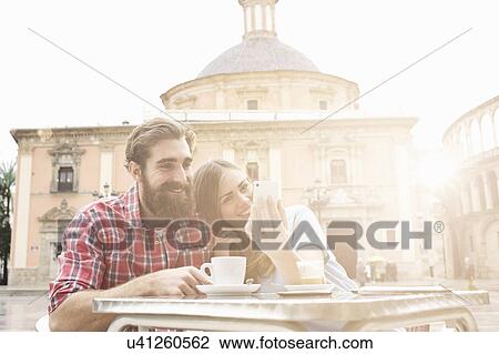 Young couple having coffee in sidewalk cafe, Plaza de la Virgen, Valencia, Spain View Large Photo Image Stock Image - Young couple having coffee in sidewalk cafe, Plaza de la Virgen, Valencia, Spain. Fotosearch