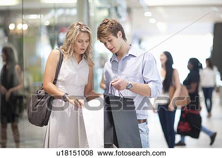Stock Photo - Young couple shopping in mall. Fotosearch