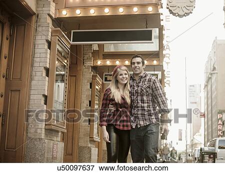 Stock Photo - Young couple strolling outside theatre, New York City, USA. Fotosearch