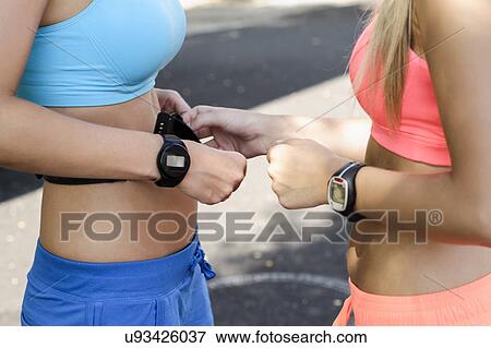 Young female athletes checking heart rate monitors View Large Photo Image Stock Photo - Young female athletes checking heart rate monitors. Fotosearch