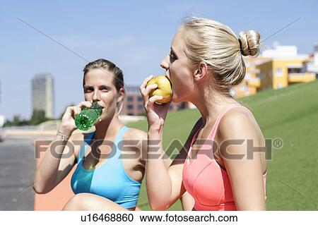 Young female athletes taking a nutrition break View Large Photo Image Stock Image - Young female athletes taking a nutrition break. Fotosearch