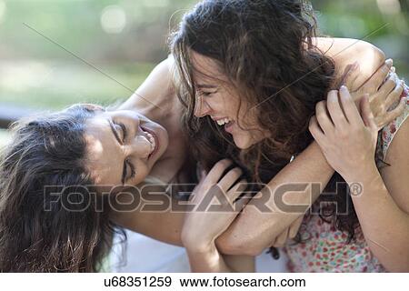 Stock Photo - Young female friends enjoying playfight. Fotosearch