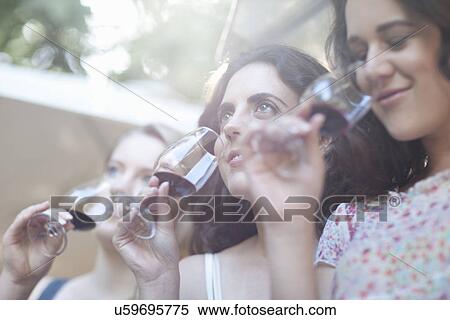 Young female friends tasting and smelling wine at vineyard View Large Photo Image Stock Photography - Young female friends tasting and smelling wine at vineyard. Fotosearch