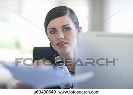 Stock Photo - Young female office passing over paperwork. Fotosearch