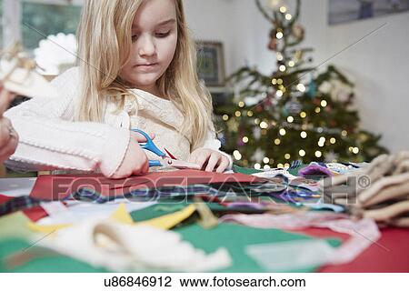 Young girl cutting out paper with scissors View Large Photo Image Stock Image - Young girl cutting out paper with scissors. Fotosearch