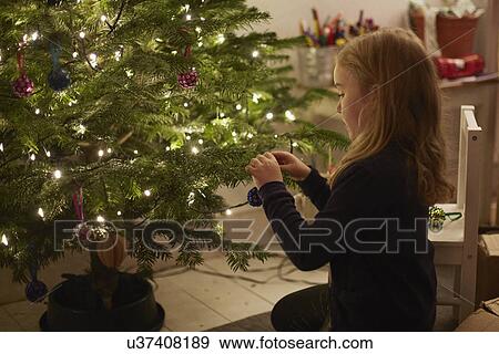Young girl decorating christmas tree View Large Photo Image Stock Photo - Young girl decorating christmas tree. Fotosearch