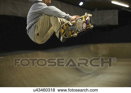 Stock Photo - Young man doing skateboard trick. Fotosearch