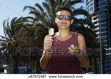 Stock Image - Young man enjoying ice lolly, Port Melbourne, Melbourne, Australia. Fotosearch