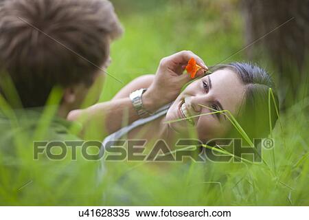 Young man putting flower in woman's hair View Large Photo Image Stock Photography - Young man putting flower in woman's hair. Fotosearch