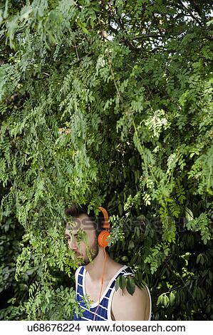 Picture - Young man running through wooded park. Fotosearch