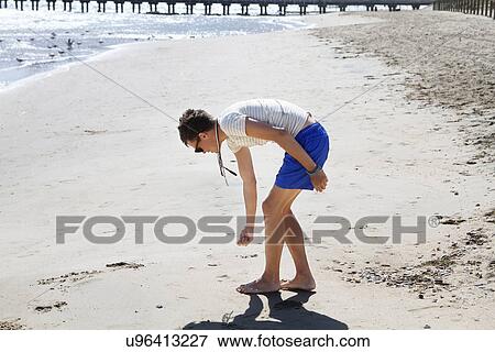 Young man searching for seashells on beach, Port Melbourne, Melbourne, Australia View Large Photo Image Stock Photo - Young man searching for seashells on beach, Port Melbourne, Melbourne, Australia. Fotosearch