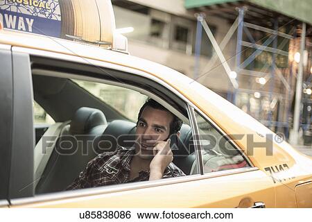 Young man using cellphone in yellow cab, New York City, USA View Large Photo Image Stock Photograph - Young man using cellphone in yellow cab, New York City, USA. Fotosearch