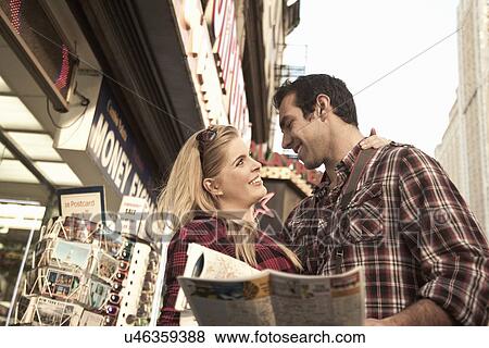 Stock Photo - Young tourist couple holding maps, New York City, USA. Fotosearch