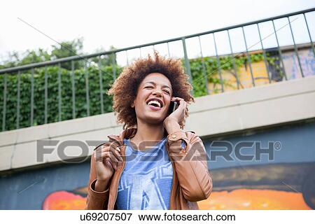 Stock Photo - Young woman chatting on smartphone. Fotosearch