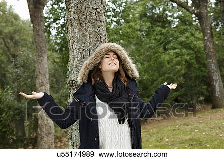 Stock Photo - Young woman enjoying air in forest. Fotosearch