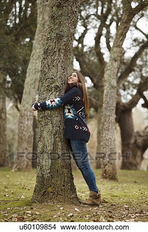 Picture - Young woman hugging tree in forest. Fotosearch
