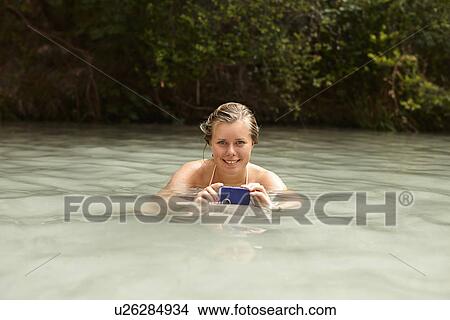 Young woman in rock pool holding an underwater camera View Large Photo Image Picture - Young woman in rock pool holding an underwater camera. Fotosearch