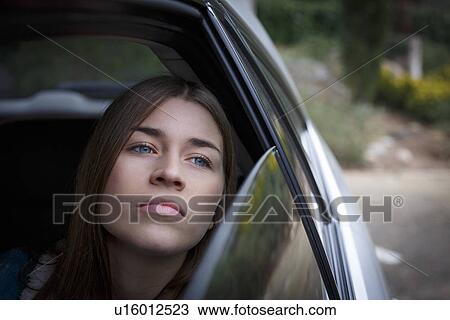 Stock Image - Young woman inside car. Fotosearch