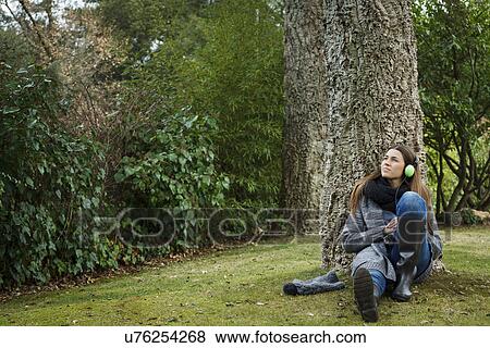 Young woman listening to music in forest View Large Photo Image Stock Photo - Young woman listening to music in forest. Fotosearch