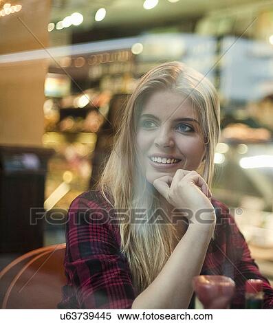 Young woman looking out of cafe window View Large Photo Image Stock Photography - Young woman looking out of cafe window. Fotosearch