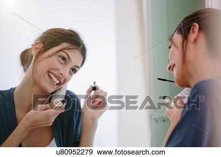 Young woman on phone getting ready to go out View Large Photo Image Stock Photo - Young woman on phone getting ready to go out. Fotosearch