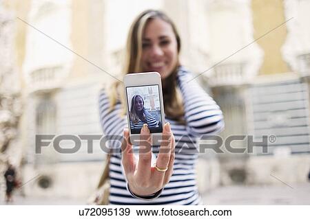 Stock Photo - Young woman posing for self portrait outside Museum of Ceramics, Valencia, Spain. Fotosearch