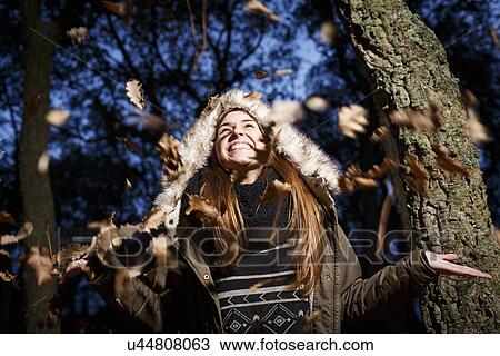 Young woman scattering leaves into air View Large Photo Image Stock Image - Young woman scattering leaves into air. Fotosearch