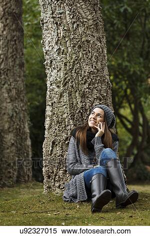 Young woman using cellular phone in forest View Large Photo Image Stock Photography - Young woman using cellular phone in forest. Fotosearch