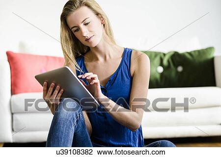 Young woman using digital tablet View Large Photo Image Stock Image - Young woman using digital tablet. Fotosearch