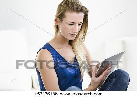 Young woman using digital tablet View Large Photo Image Stock Photograph - Young woman using digital tablet. Fotosearch